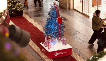Строительный кран поднял новогоднюю елку в ГУМе над праздничным городом