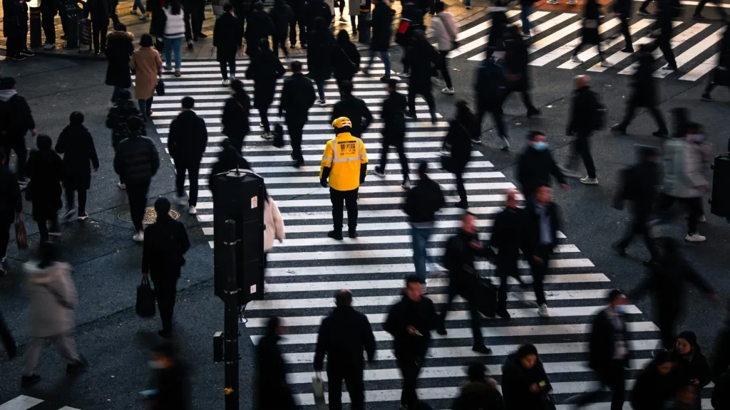 Пеший курьер с рюкзаком-термосом проверяет маршрут в мобильном приложении на смартфоне. Пеший курьер с рюкзаком-термосом проверяет маршрут в мобильном приложении на смартфоне.